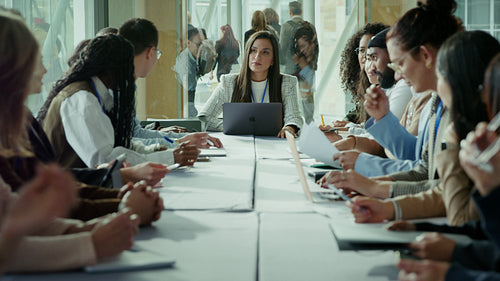 Confident businesswoman leading boardroom meeting with professionals