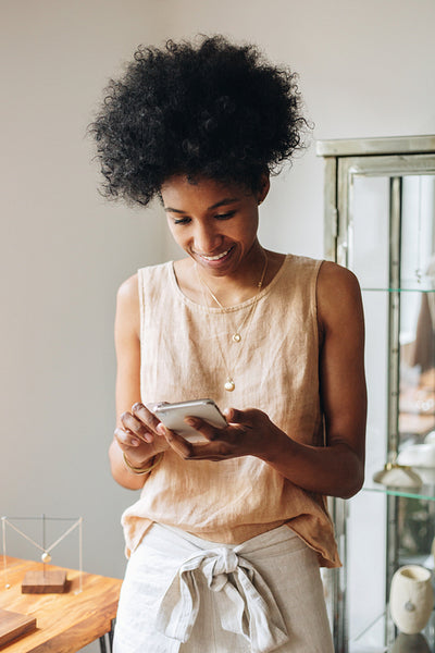 Jeweler checking for new orders of ornaments on phone