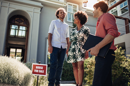 Young couple outside a house with real estate agent