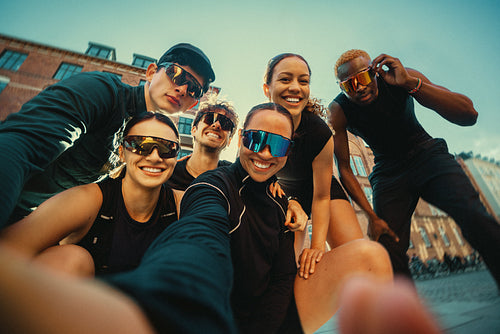 Group running friends gather for a selfie before an outdoor run club event