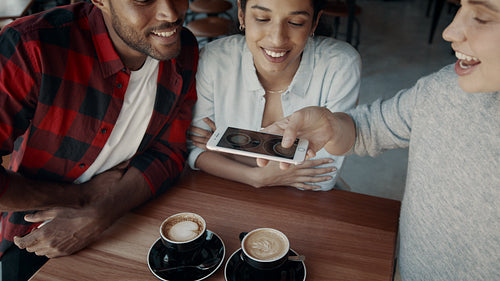 Friends hanging out a coffee shop taking photos of coffee