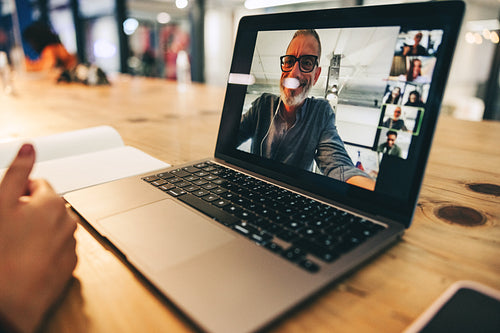 Anonymous businesswoman attending a virtual meeting in a modern office