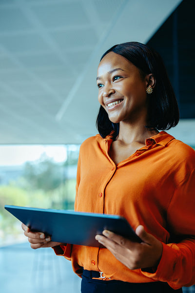 Confident business professional holding a digital tablet in modern office