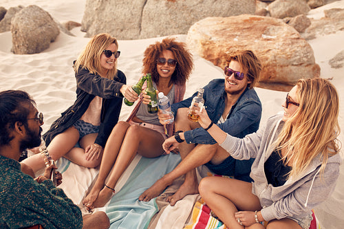 Best friends drinking beer at the beach