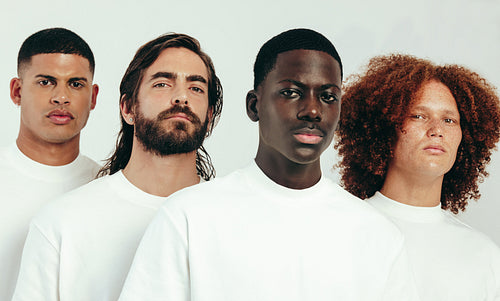 Group of diverse young men with unique skin types standing in a studio