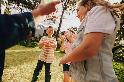 Children playing with water balloons outdoors on a sunny day