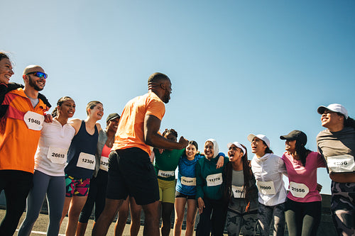 Group of runners in a pre-race pep talk session outdoors