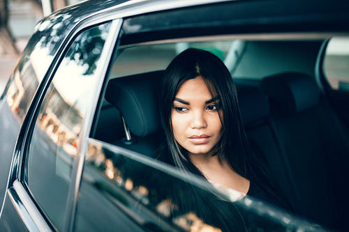 Beautiful young businesswoman travelling by a car