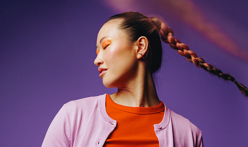 Bold Asian beauty portrait with expressive makeup and braided hair