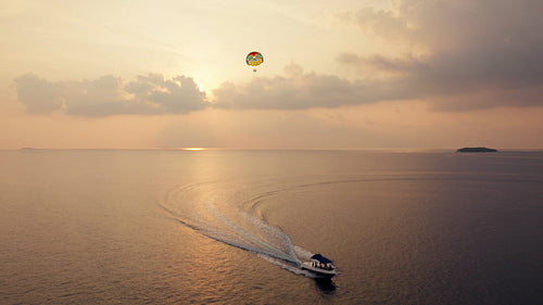 Sunset parasailing adventure at sunset over a vast tropical ocean