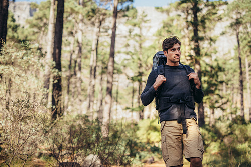 Man hiking in forest wearing a backpack