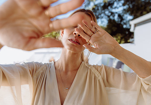 Stylish woman blocking her face with her hands
