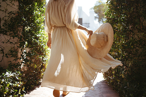 Unrecognizable tourist woman walking in a flowy dress outdoors