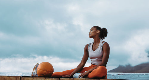 Fitness woman relaxing after workout on rooftop