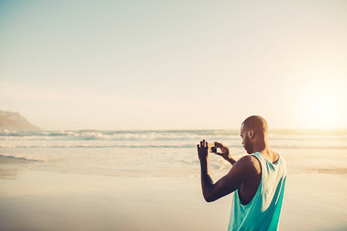 Man doing mobile photography at the sea shore