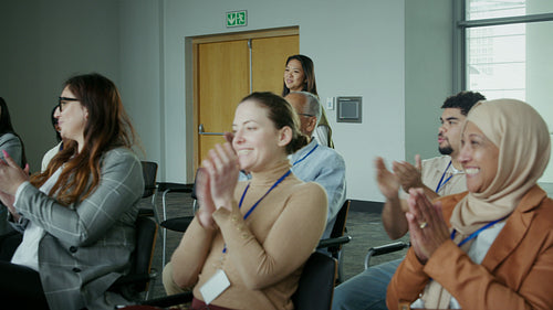 Diverse business audience enthusiastically clapping for a successful presentation