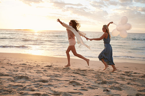 Friends with balloons on the beach enjoying summer day