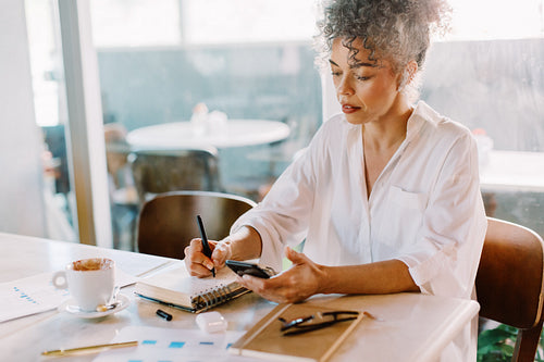 Focused businesswoman making notes in her journal