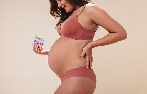 Woman using prenatal supplements for health and wellness in her pregnancy