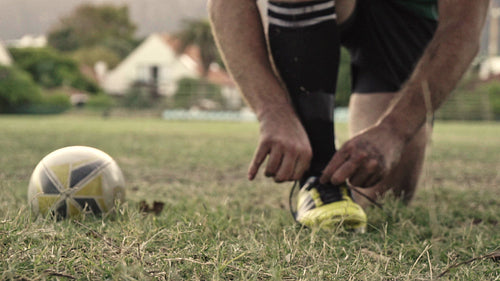 Rugby player adjusting shoelaces