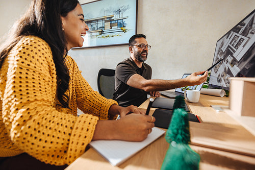 Colleagues discussing architectural designs in a modern office setting