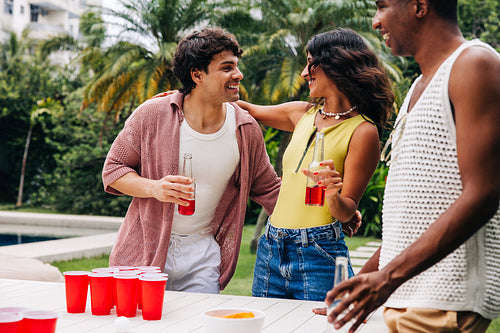 Friends play beer pong at outdoor party