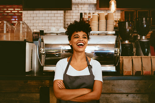 Cheerful barista in her coffee shop
