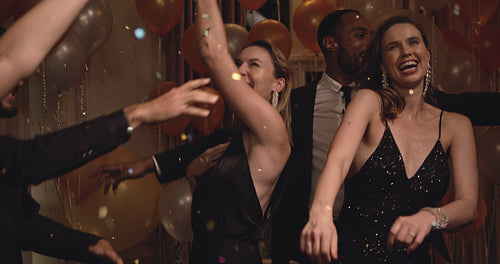 Friends dancing in the night club with confetti