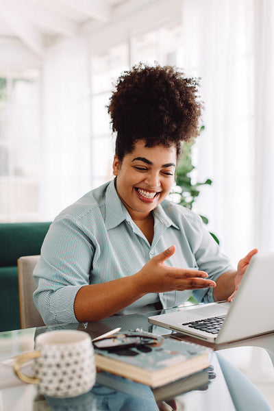 Woman working remotely video calling with laptop