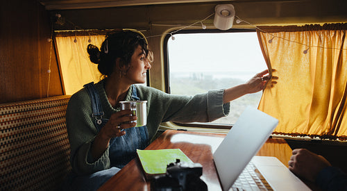 Morning focus: Woman enjoys morning coffee on a quick road trip stop