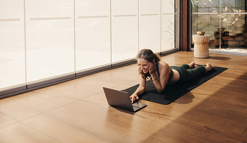 Happy elderly woman joining an online yoga class at home