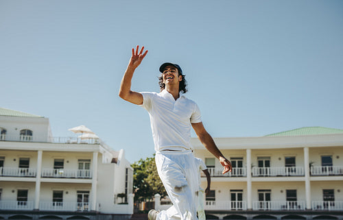 Young male cricket player celebrating during a sunny day match