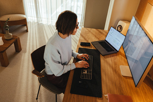 Woman works at computer desk in a home office