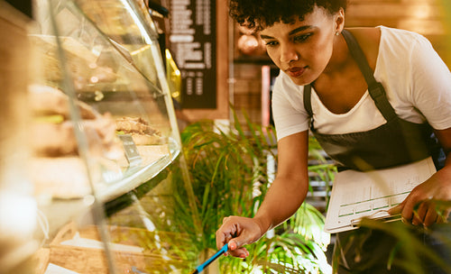 Woman checking the stock in her cafe