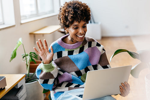 Freelancer waving hello in a vibrant co-working space