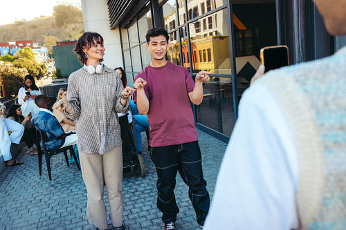 Generation Z friends performing a creative dance routine outdoors during a casual hangout, captured in a vibrant urban setting