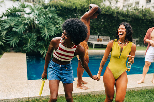 Friends enjoy a pool party by the backyard