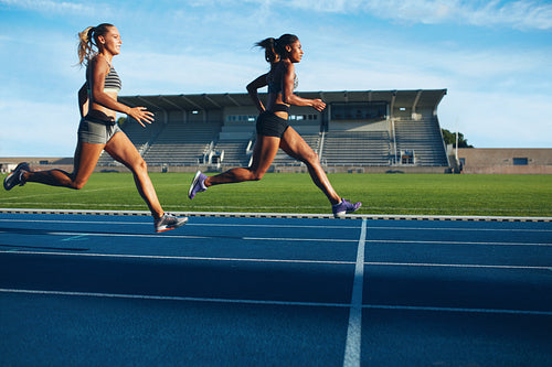 Athletes arrives at finish line on racetrack 