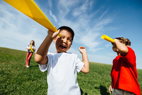 Kids pretending with playful telescopes in sunny open field