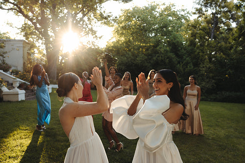 Joyful wedding celebration with friends enjoying a sunny outdoor garden gathering