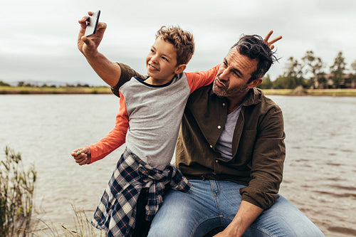 Father and son having fun taking selfie outdoors