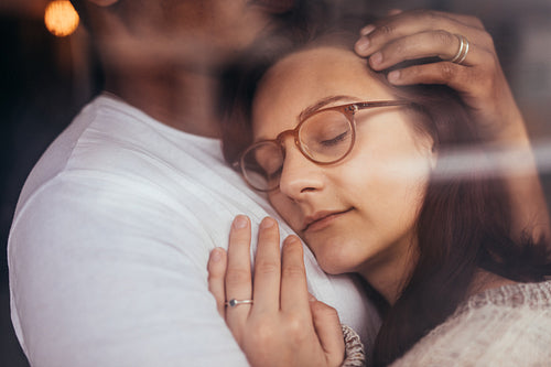 Couple in love embracing behind window