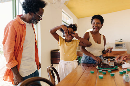 Cooking and playfulness: Brazilian girl having fun making brigadeiro with her parents