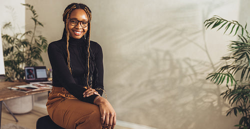 Young freelancer smiling at the camera in her office