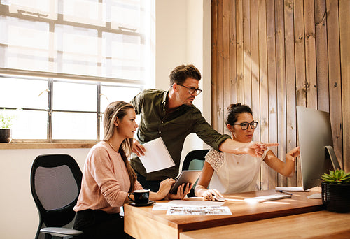 Creative business team looking at a computer and discussing