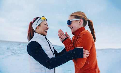 Women share warm laughter and motivation in snowy winter running