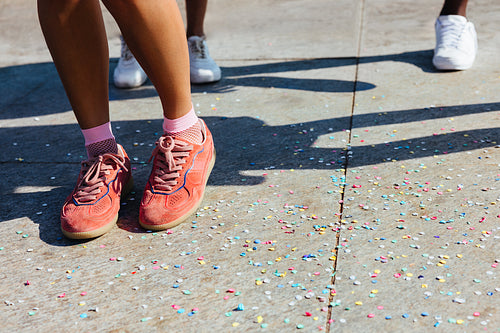 Red sneakers standing on confetti at a carnival