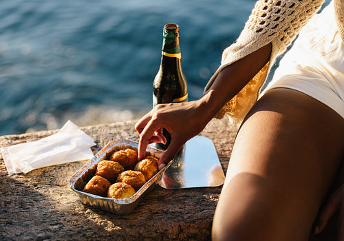 Woman enjoying Brazilian street food by the ocean