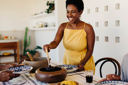 Cheerful brazilian family enjoying traditional feijoada meal at home