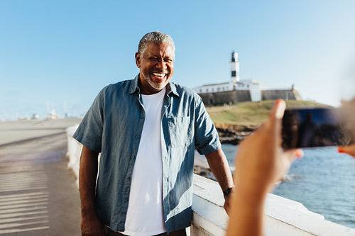 Smiling mature man posing for a photograph at Farol da Barra, Salvador